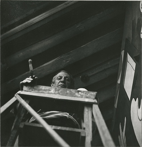 Dora Maar, Picasso sur un escabeau dans l'atelier des Grands-Augustins, mai-juin 1937, Paris, Musée national Picasso – Paris, Photo (C) RMN-Grand Palais (Musée national Picasso-Paris) / image RMN-GP, © ADAGP, © Succession Picasso 2021.