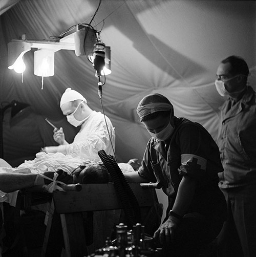 Lee Miller, Chirurgien et anesthésiste réalisant une opération dans le 44e hôpital de campagne près de La Cambe en Normandie. France, 1944. © Lee Miller Archives, England 2022.