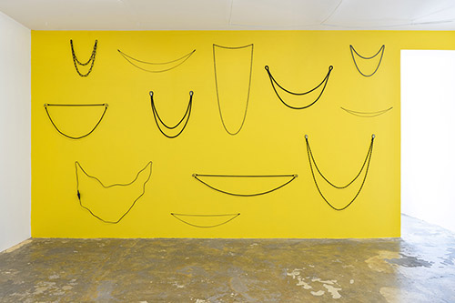 Elsa Werth, Blind Smile, 2021. Installation murale, peinture jaune, câbles, chaînes, cordes, tendeurs, dimensions variables. Vue de l'exposition Avalanche, Trois a, Toulouse. Courtesy de l’artiste.