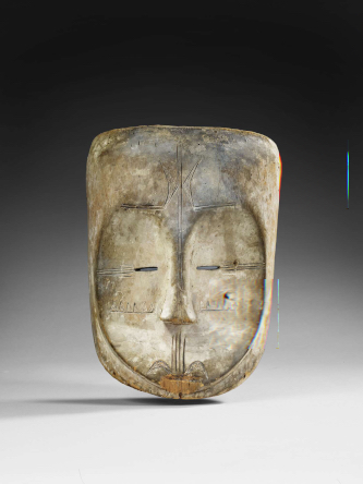 Masque anthropomorphe ngon ntang. N° inventaire 71.1941.13.14. Visage ovale s'évasant au niveau du front. Haut du crâne plat. Face légèrement concave. Figuration de tatouages linéaires par incision au niveau du front, des tempes. Triangles sur les joues. Lignes plus sinueuses au niveau de la bouche. Yeux figurés par deux fentes horizontales. Nez mince,dans le prolongement des lignes des arcades sourcilières. Bouche abîmée à la hauteur du menton. 19e siècle. Bois, kaolin. 25 x 19,4 x 16,4 cm, 770 g. Population, Fang. Afrique Gabon Afrique centrale. © musée du quai Branly - Jacques Chirac, photo Claude Germain